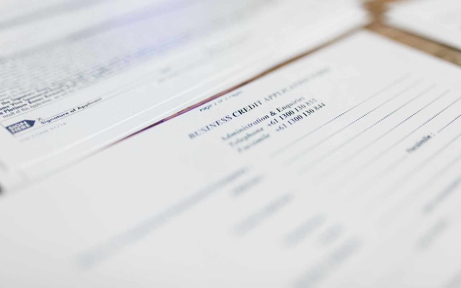 Close-up of a business credit application form with contact phone numbers printed on it