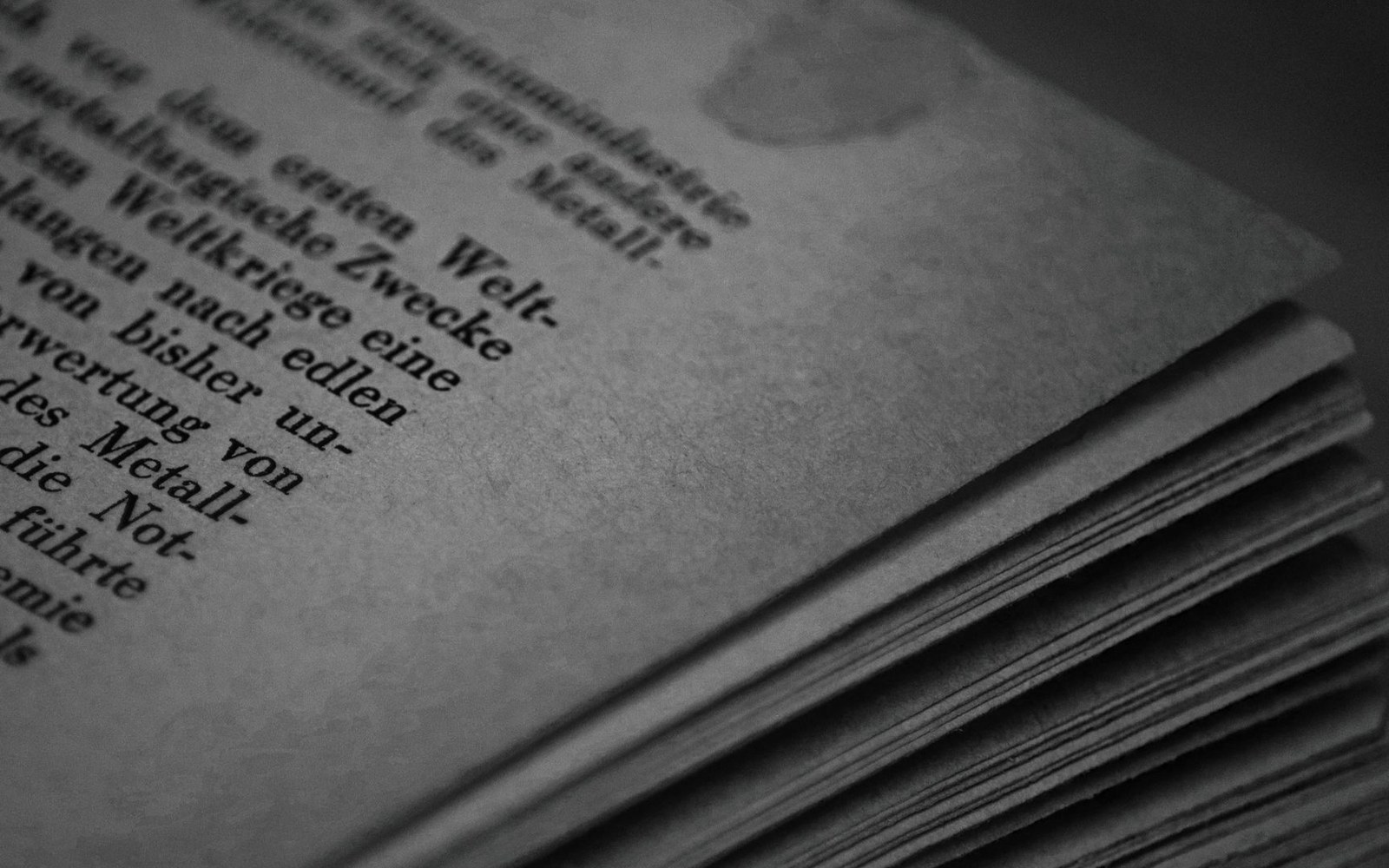 Close-up of an aged book's yellowed pages with German text and a stained corner