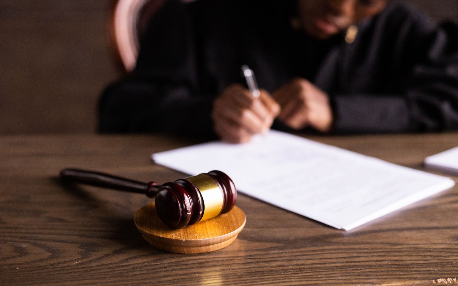 A printed copy of Uber BV v Aslam opened flat to the held paragraphs on a plain wooden surface, with a hand visible at the edge