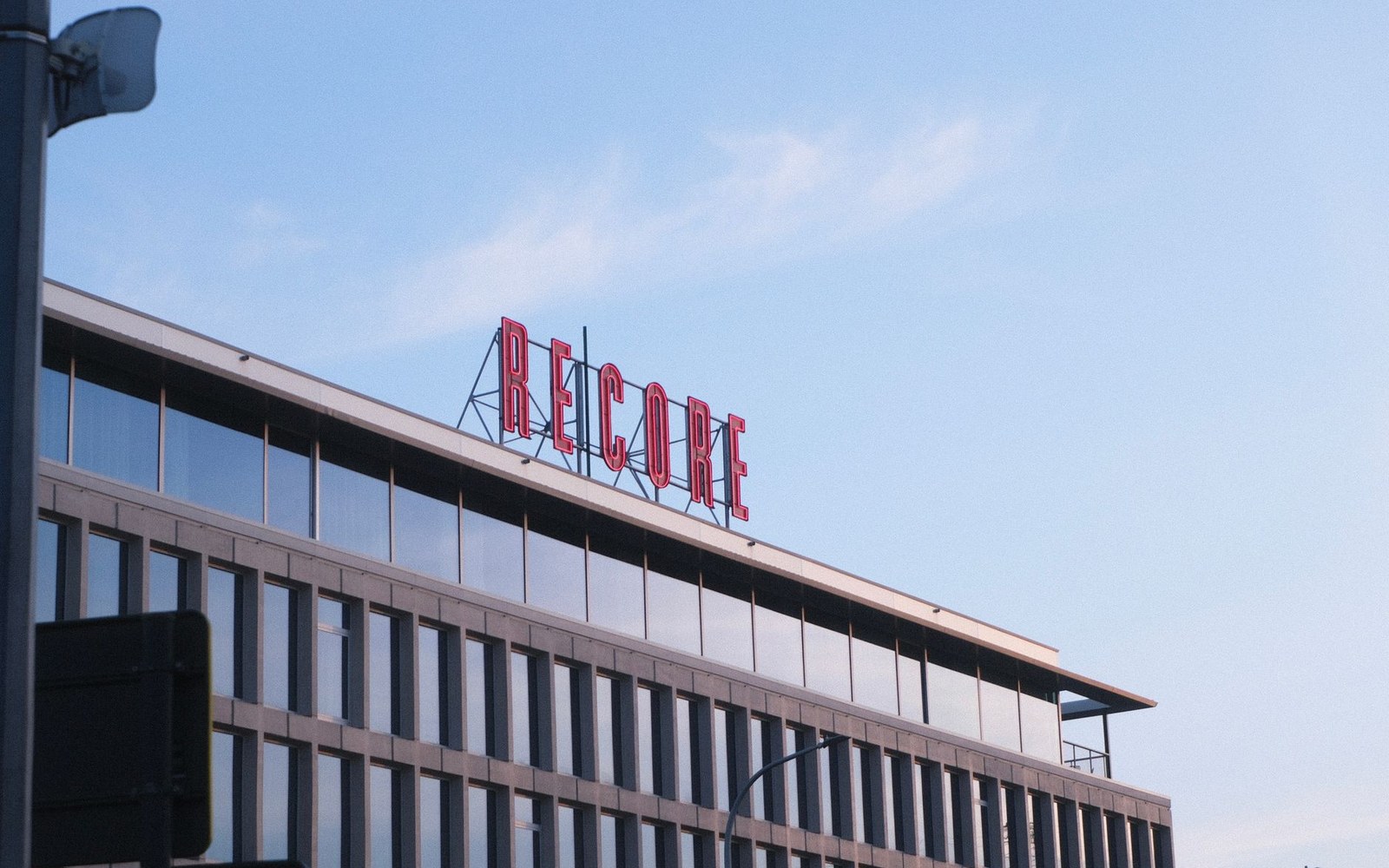 A WeWork location sign on a building exterior in an urban street, photographed from pavement level